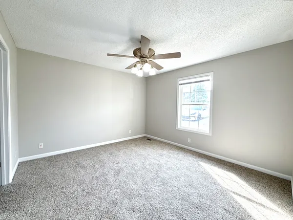 a view of an empty room with a ceiling fan