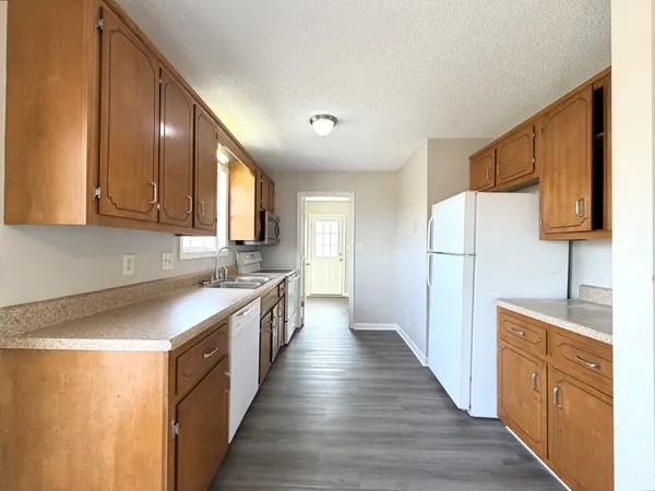 a kitchen with a sink wooden floor and a window