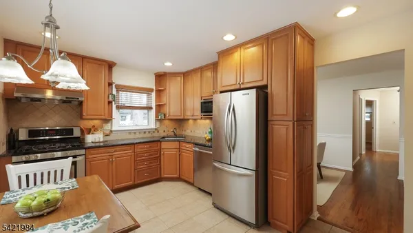 a kitchen with stainless steel appliances granite countertop a refrigerator a sink a stove and island