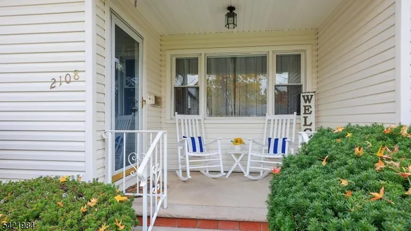 front view of a house with a chairs and table in a patio