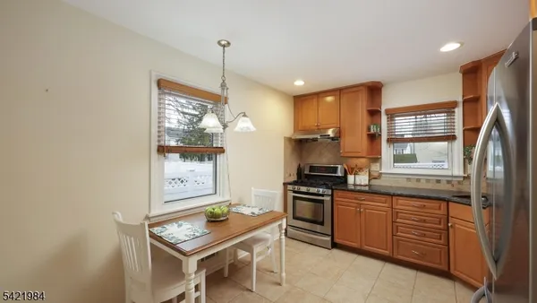 a kitchen with stainless steel appliances granite countertop a stove refrigerator sink and cabinets