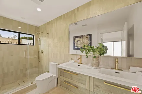 a bathroom with a double vanity sink toilet and shower