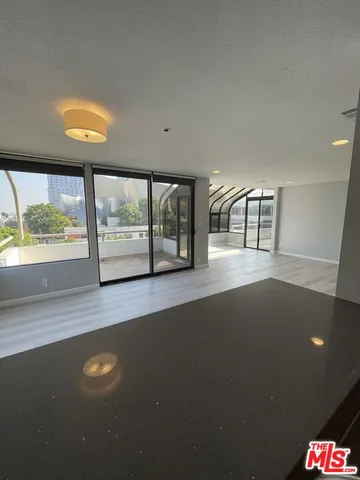 an empty room with large window and wooden floor