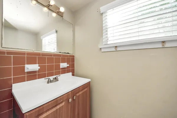 a bathroom with a sink a vanity and a window