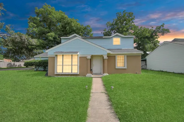 a front view of a house with a garden and yard