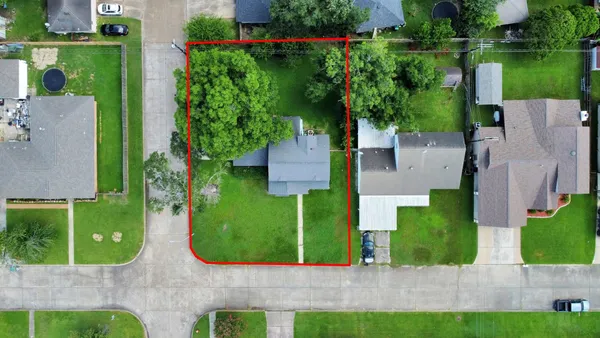 front view of a house with a yard and potted plants