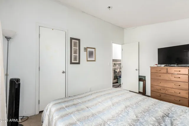 a bedroom with a bed and a flat tv screen in a room