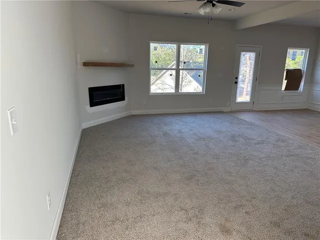 an empty room with windows and fireplace