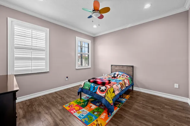 a bedroom with a bed and a flat tv screen on dresser