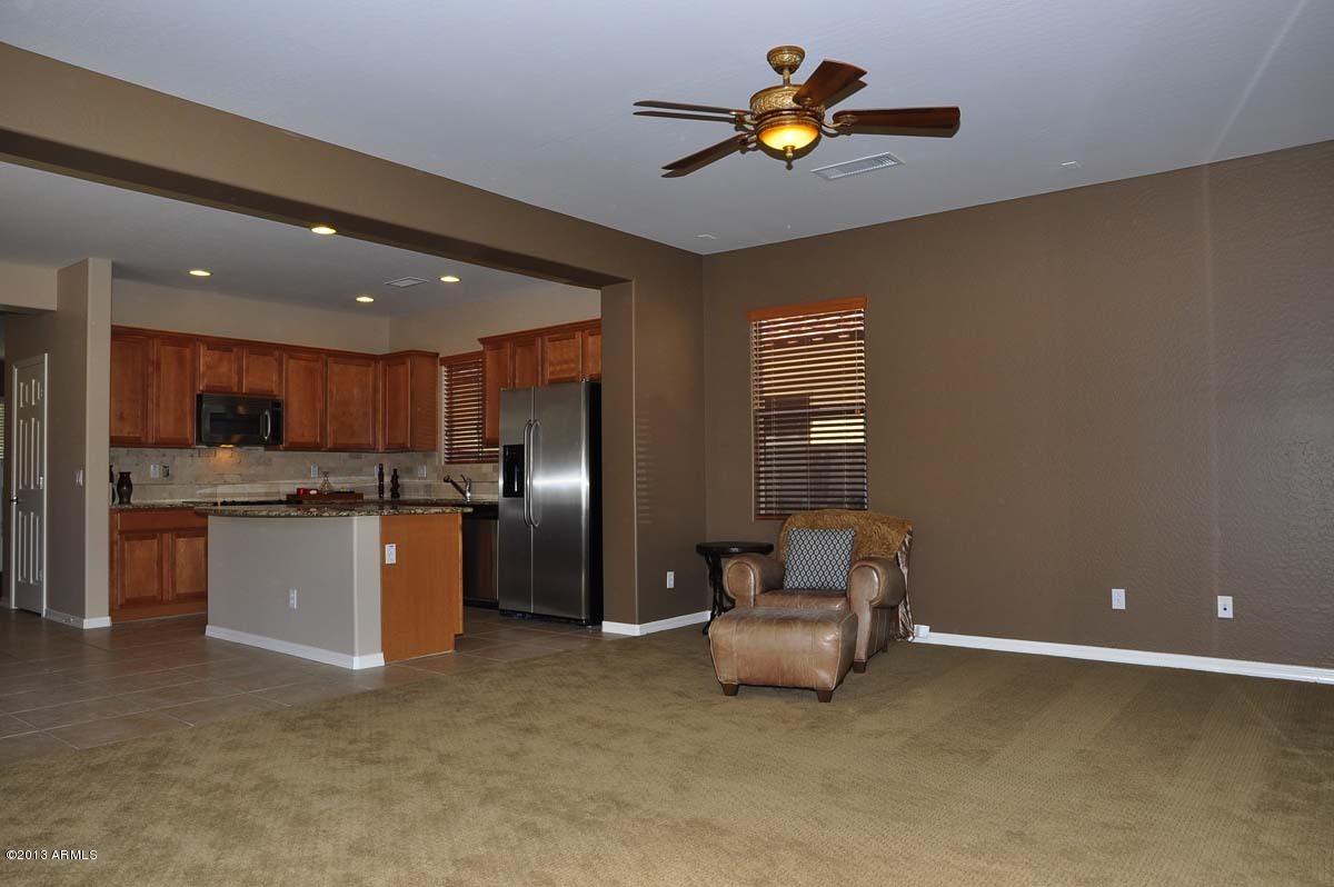 20798 West Ridge Road Buckeye, AZ 85396 - Photo 16 of 47 a kitchen with stainless steel appliances kitchen island granite countertop a refrigerator and a stove top oven