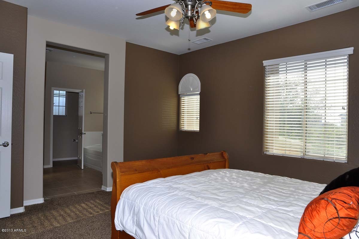 20798 West Ridge Road Buckeye, AZ 85396 - Photo 28 of 47 a bedroom with a bed and a chandelier