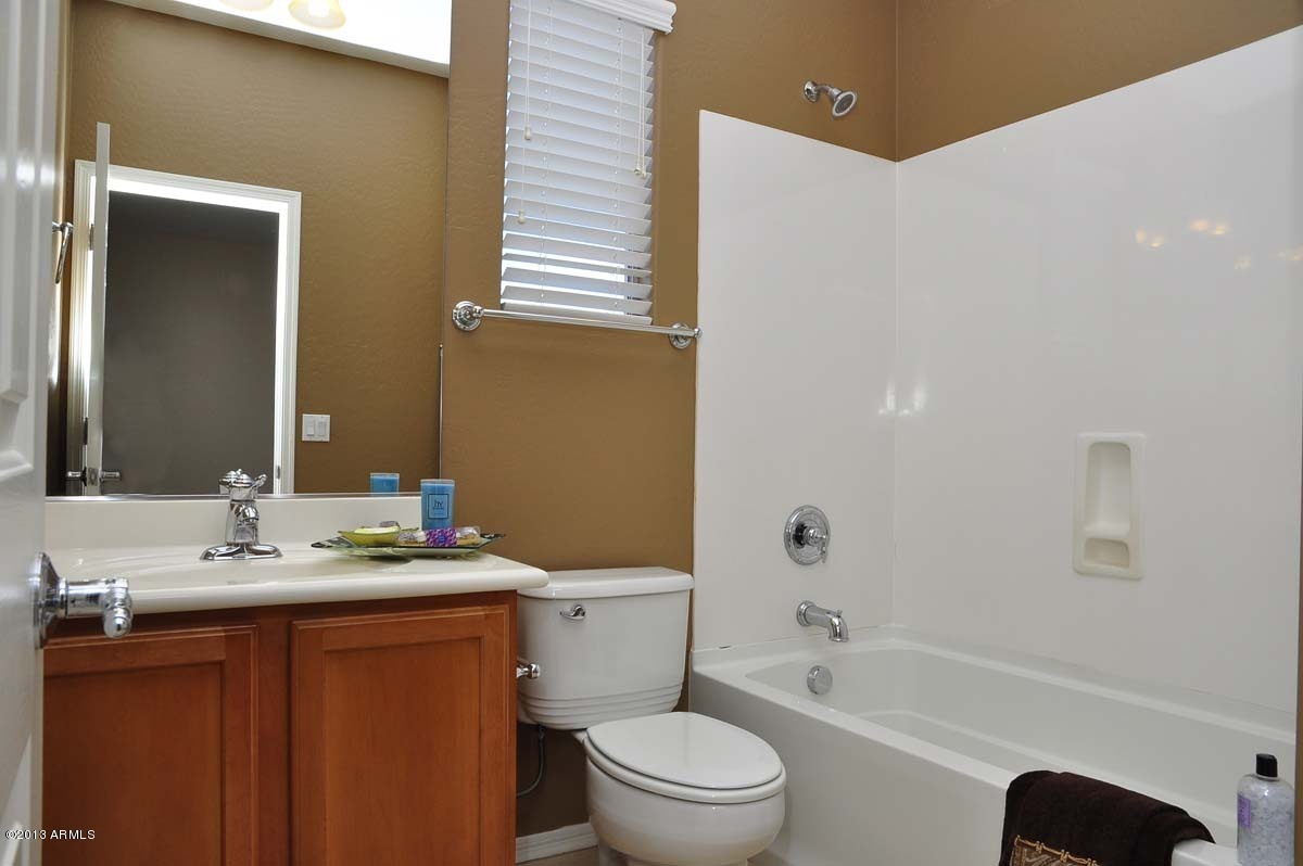 20798 West Ridge Road Buckeye, AZ 85396 - Photo 33 of 47 a bathroom with a bathtub shower sink vanity mirror and toilet