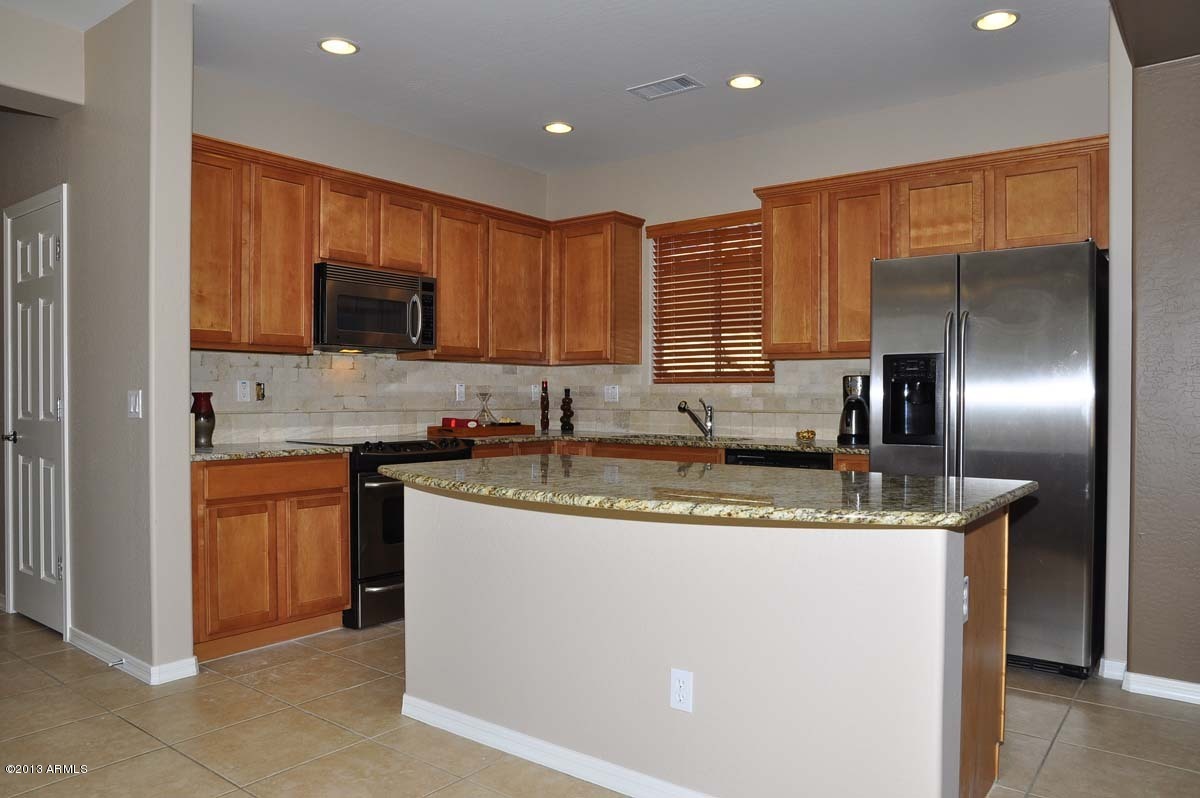 20798 West Ridge Road Buckeye, AZ 85396 - Photo 9 of 47 a kitchen with stainless steel appliances granite countertop a sink a stove and a refrigerator