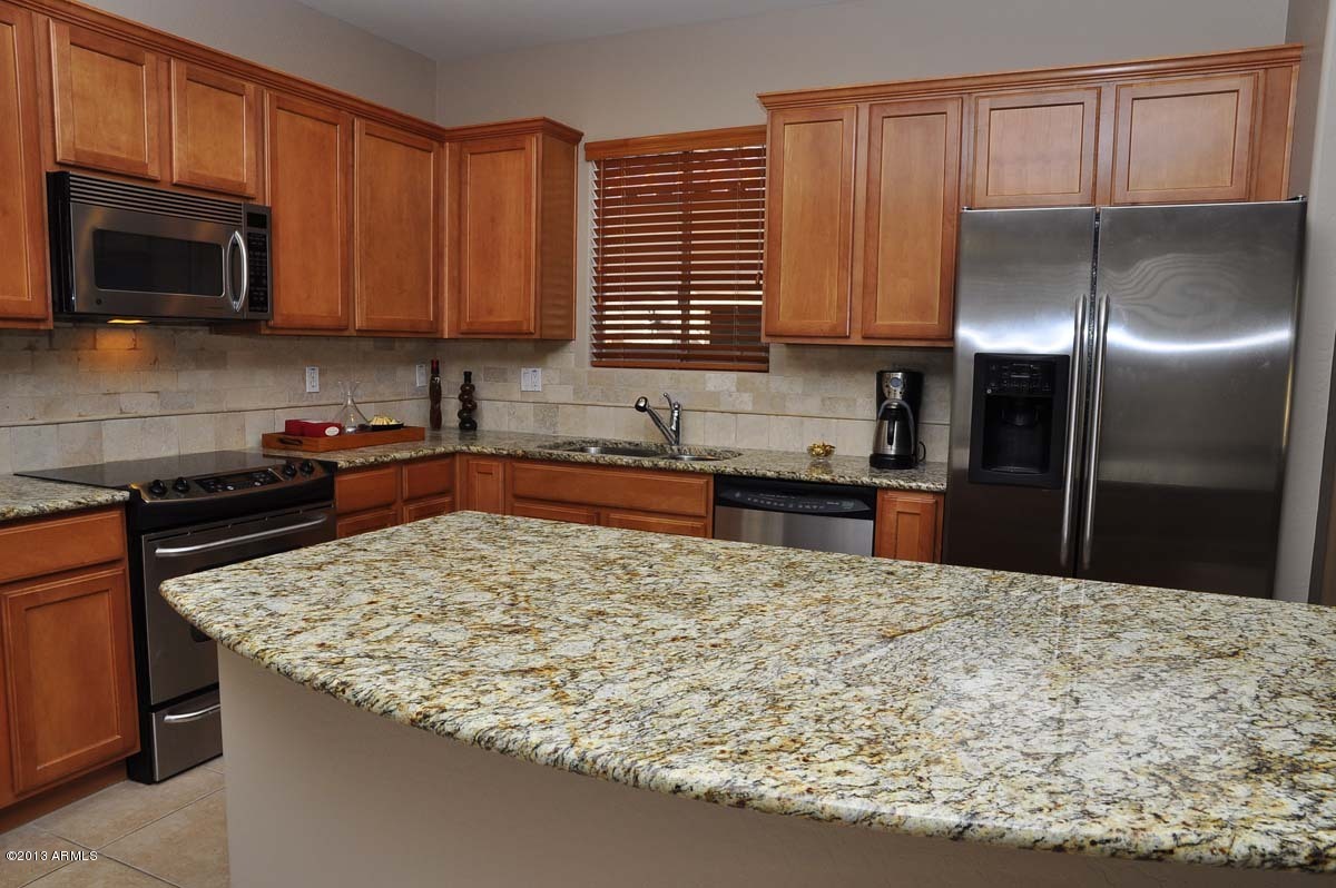20798 West Ridge Road Buckeye, AZ 85396 - Photo 10 of 47 a kitchen with stainless steel appliances granite countertop a sink stove and microwave