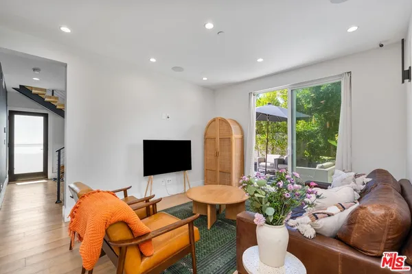 a living room with furniture potted plant and a flat screen tv