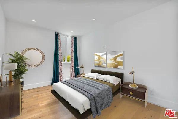 a bedroom with a bed and wooden floor