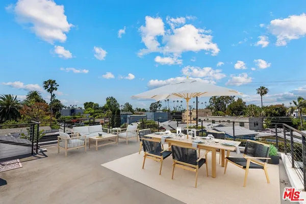 a view of a patio with dining table and chairs