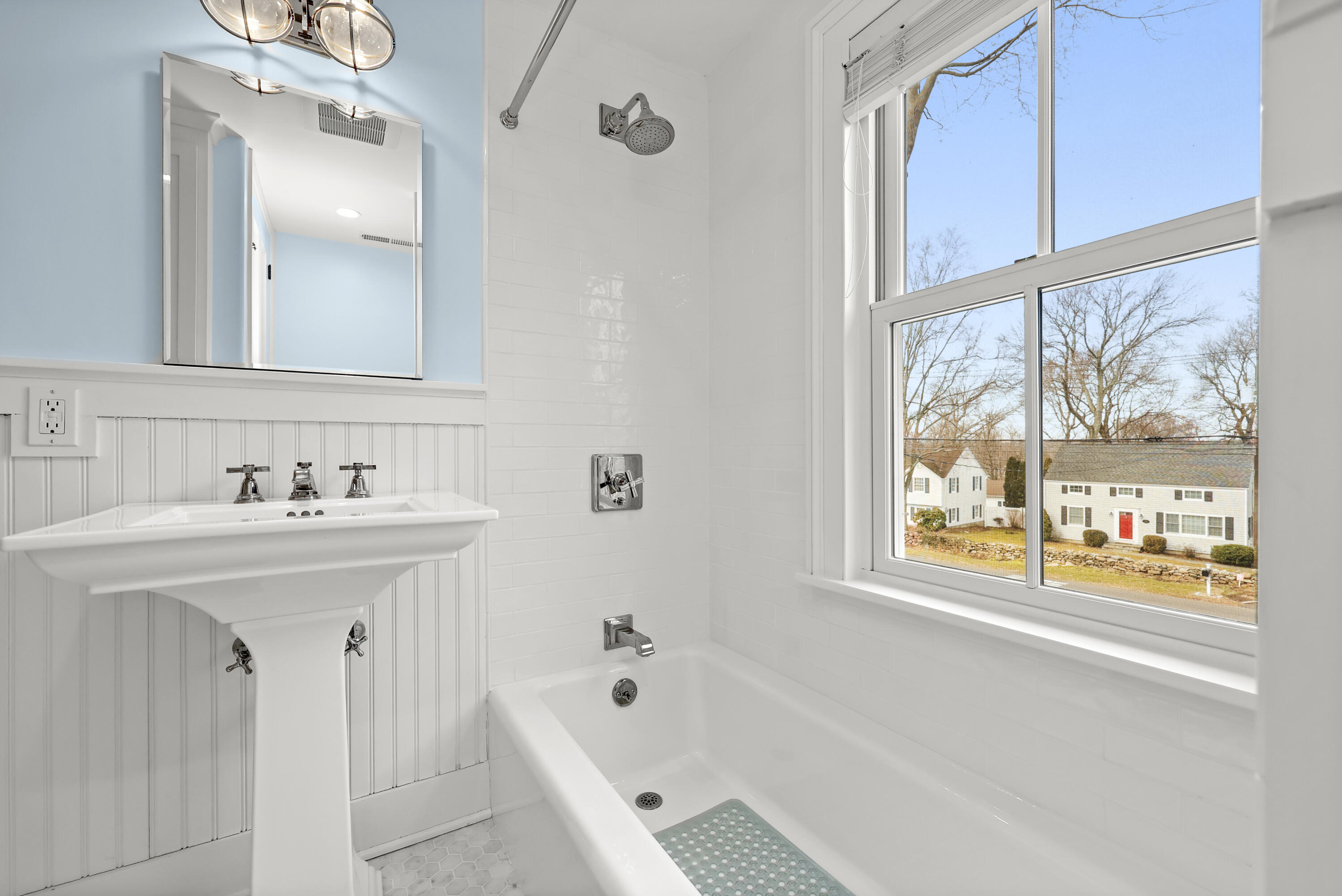100 Hollow Tree Ridge Road Darien, CT 06820 - Photo 30 of 38 a bathroom with a bathtub a sink a window and a mirror