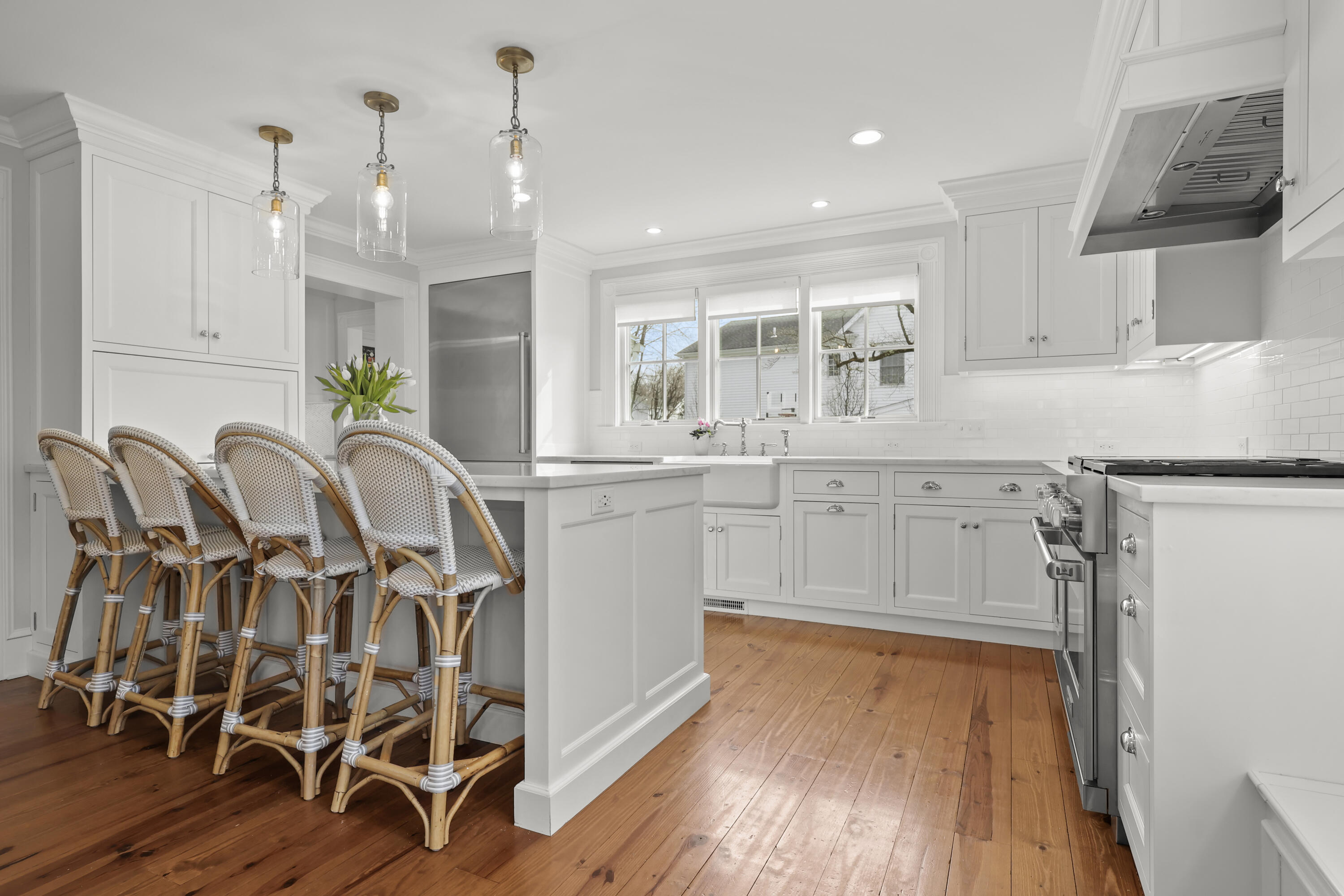 100 Hollow Tree Ridge Road Darien, CT 06820 - Photo 6 of 38 a kitchen with cabinets a sink dishwasher a dining table and chairs with wooden floor