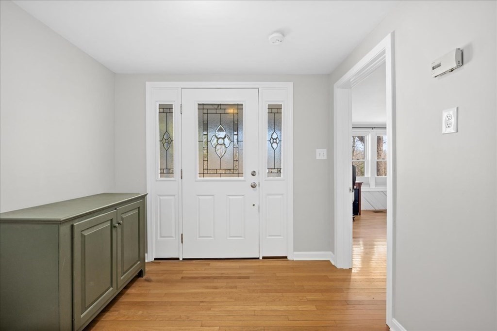 11 Merrill Road Sutton, MA 01590 - Photo 5 of 42 a view of a hallway with wooden floor and a living room