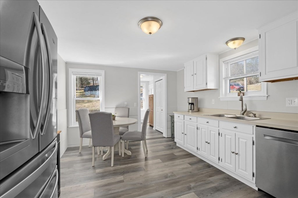 11 Merrill Road Sutton, MA 01590 - Photo 8 of 42 a kitchen with granite countertop a dining table chairs stainless steel appliances and cabinets
