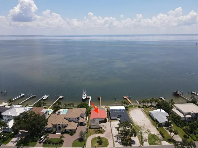 an aerial view of a city with lots of residential buildings ocean and mountain view in back