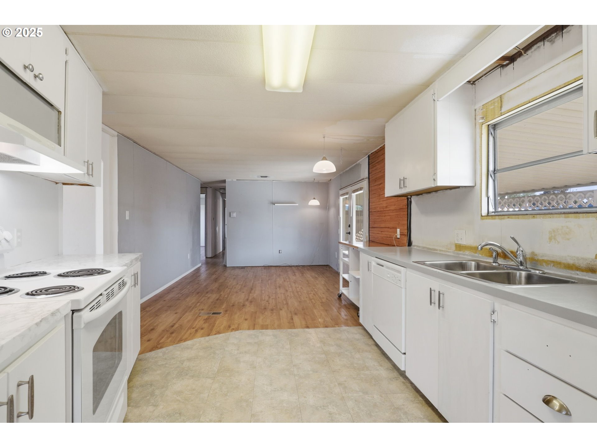 2902 East 2nd Street, Unit 67 Newberg, OR 97132 - Photo 13 of 38 a kitchen with granite countertop a stove a sink and a refrigerator