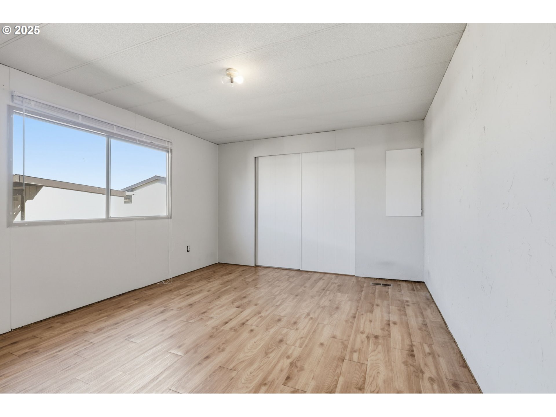 2902 East 2nd Street, Unit 67 Newberg, OR 97132 - Photo 18 of 38 an empty room with wooden floor closet and windows