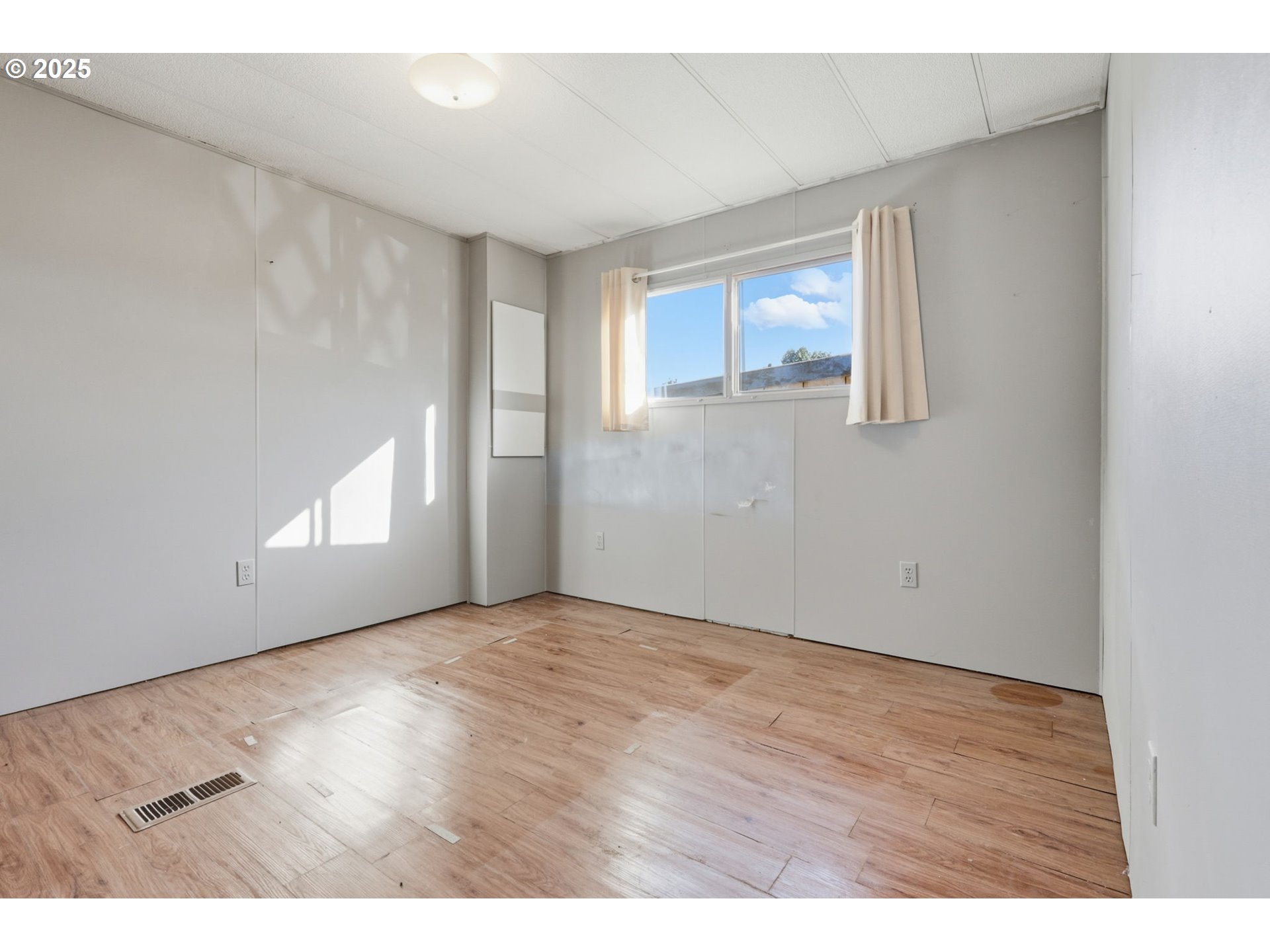 2902 East 2nd Street, Unit 67 Newberg, OR 97132 - Photo 21 of 38 a view of an empty room with wooden floor and a window