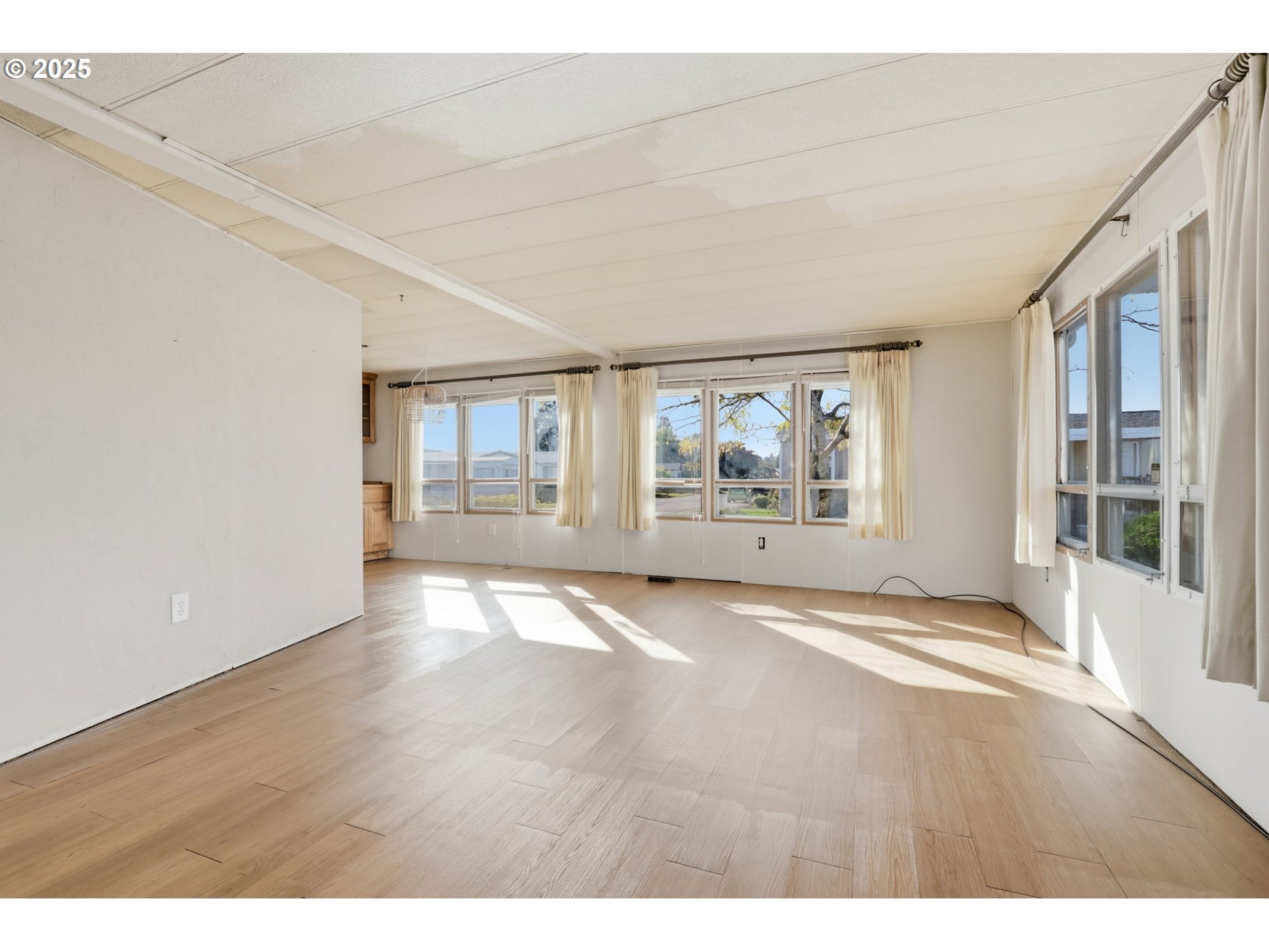 2902 East 2nd Street, Unit 67 Newberg, OR 97132 - Photo 7 of 38 an empty room with wooden floor and windows