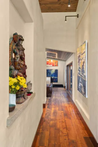 a living room with a bed wooden floor and a large window