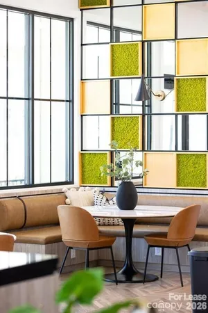 a room with a table chairs and a window