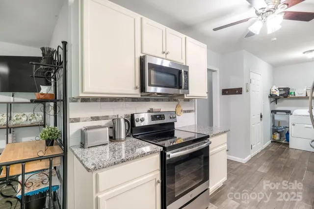 a kitchen with stainless steel appliances granite countertop a stove microwave and sink
