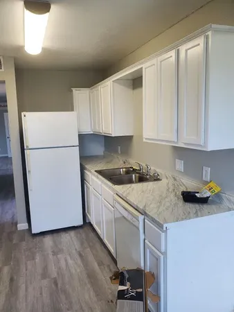 a kitchen with a sink a stove a refrigerator and cabinets
