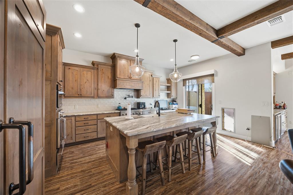3105 Pastor Street Dallas, TX 75212 - Photo 3 of 28 Kitchen with a breakfast bar area, wood cabinetry, pendant lighting, and Luxury Vinyl wood like floors