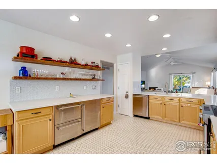 a kitchen with white cabinets and wooden floors