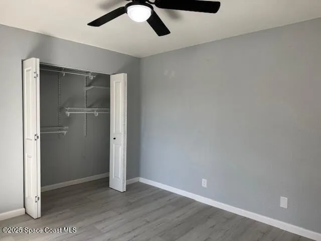 an empty room with wooden floor cabinet and closet