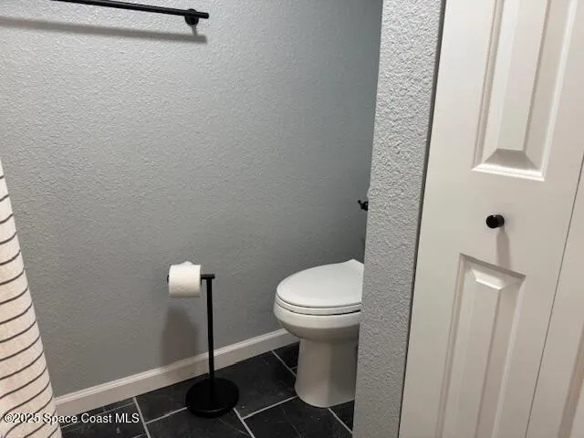 a white toilet sitting next to a white sink