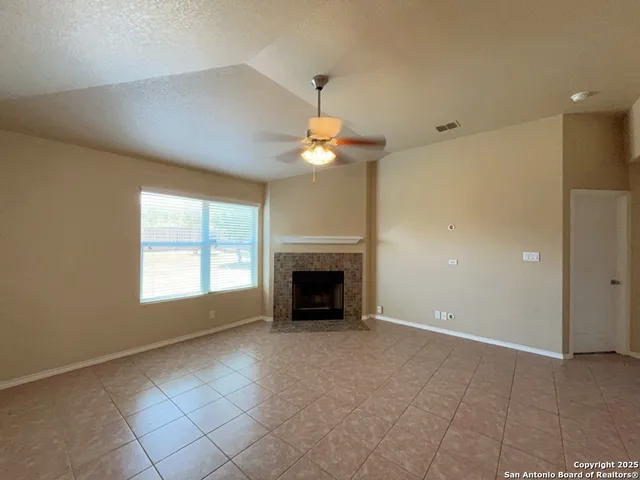 wooden floor fireplace and windows in an empty room