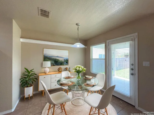a dining room with furniture potted plants and wooden floor