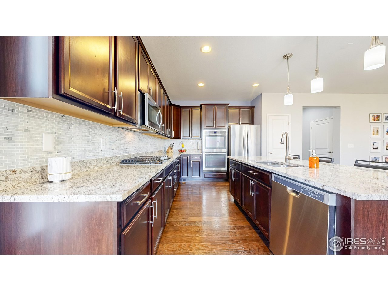 6794 Spring Rain Road Timnath, CO 80547 - Photo 12 of 49 a kitchen with stainless steel appliances granite countertop a sink stove and cabinets