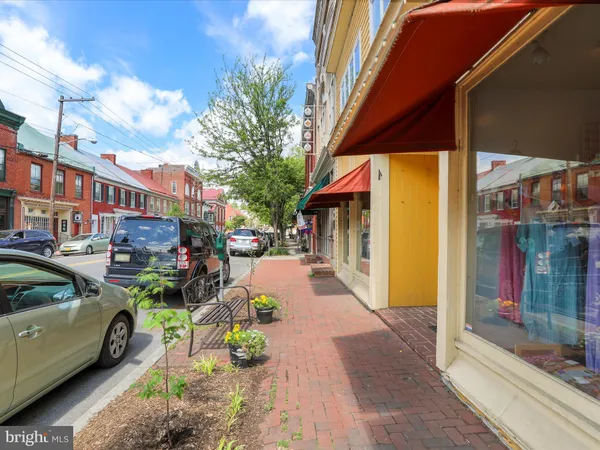 a street view with tall buildings and a cars park side of a street