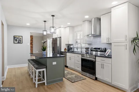 a kitchen with kitchen island stainless steel appliances a sink stove and refrigerator
