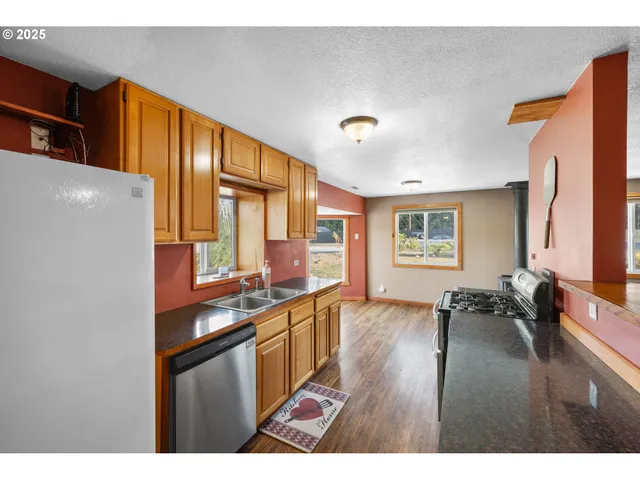 a kitchen with stainless steel appliances granite countertop a sink stove and wooden cabinets