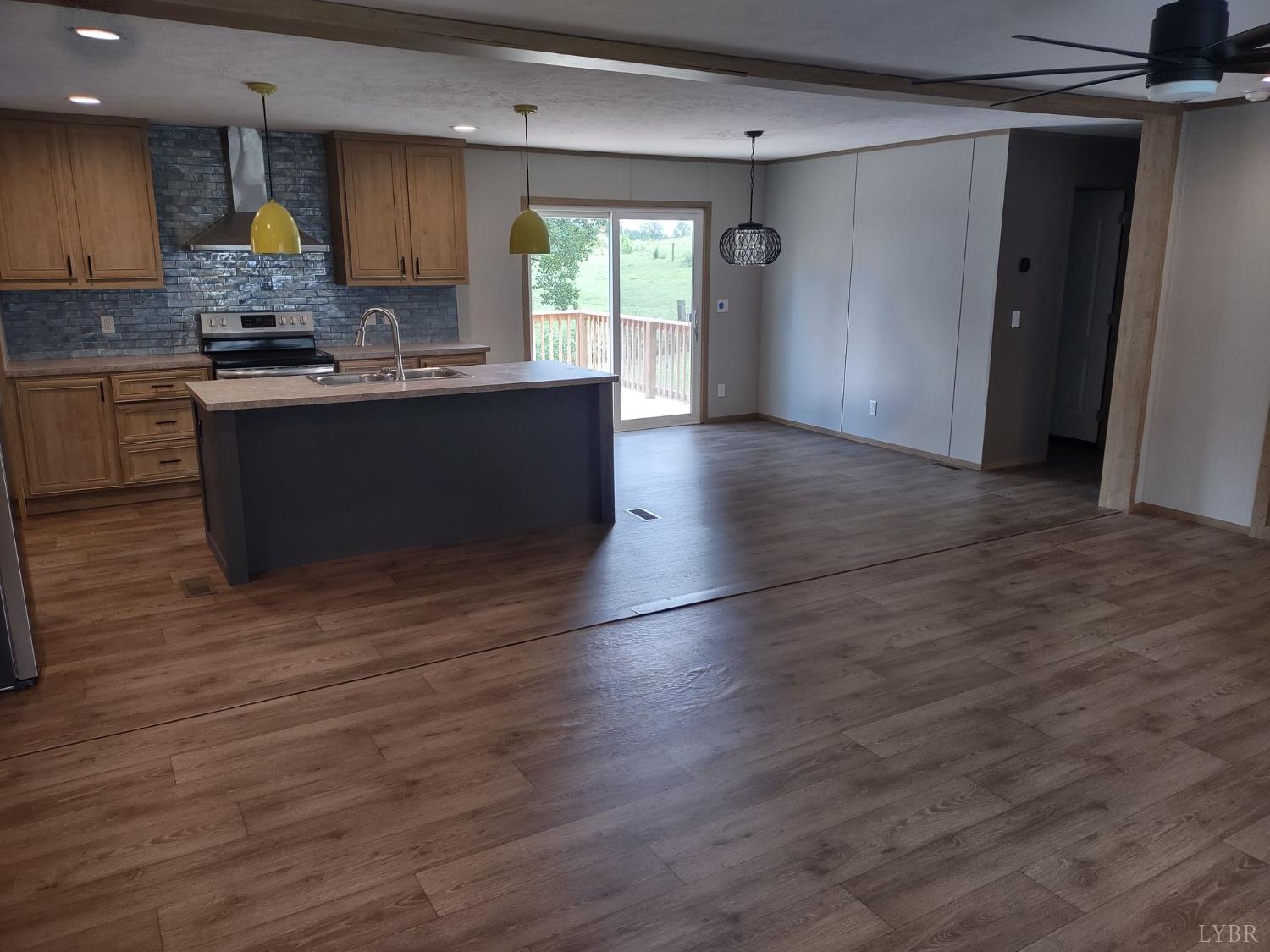 209 Lee Ford Camp Road Ridgeway, VA 24148 - Photo 3 of 19 a kitchen with stainless steel appliances granite countertop a sink a stove cabinets and wooden floor
