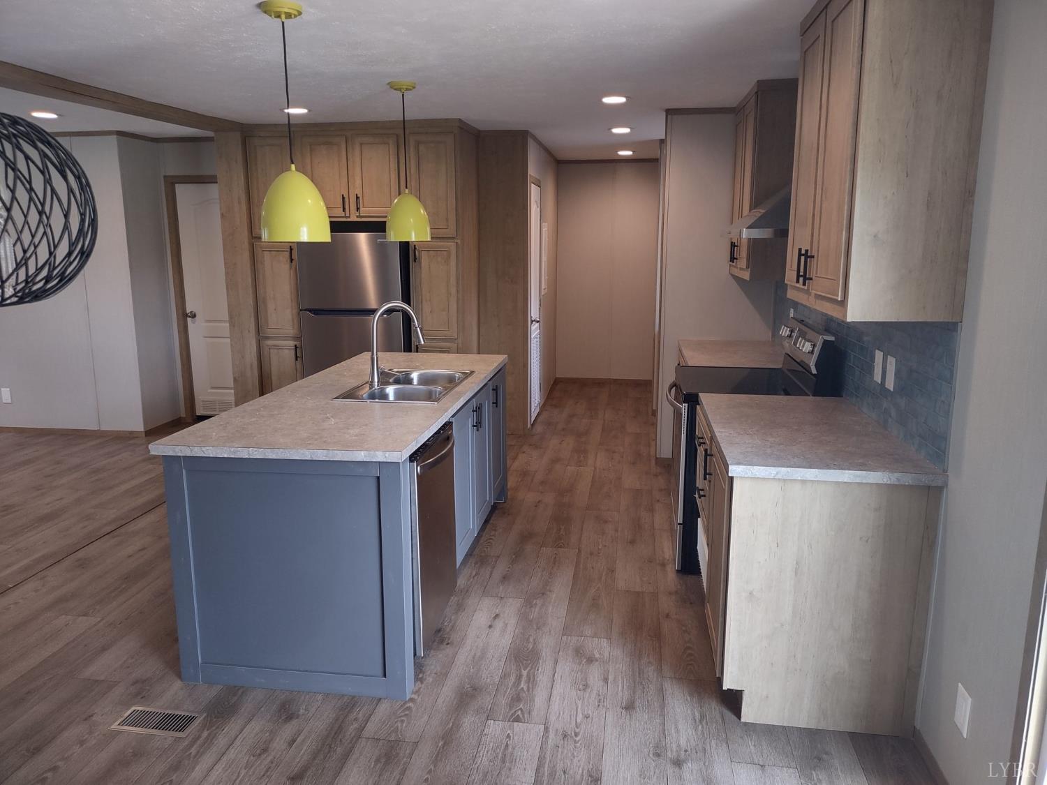 209 Lee Ford Camp Road Ridgeway, VA 24148 - Photo 4 of 19 a kitchen with a sink a refrigerator and wooden floor