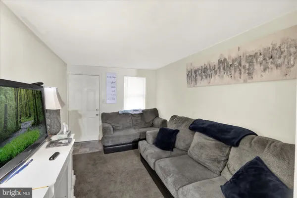 a living room with furniture a lamp and a flat screen tv
