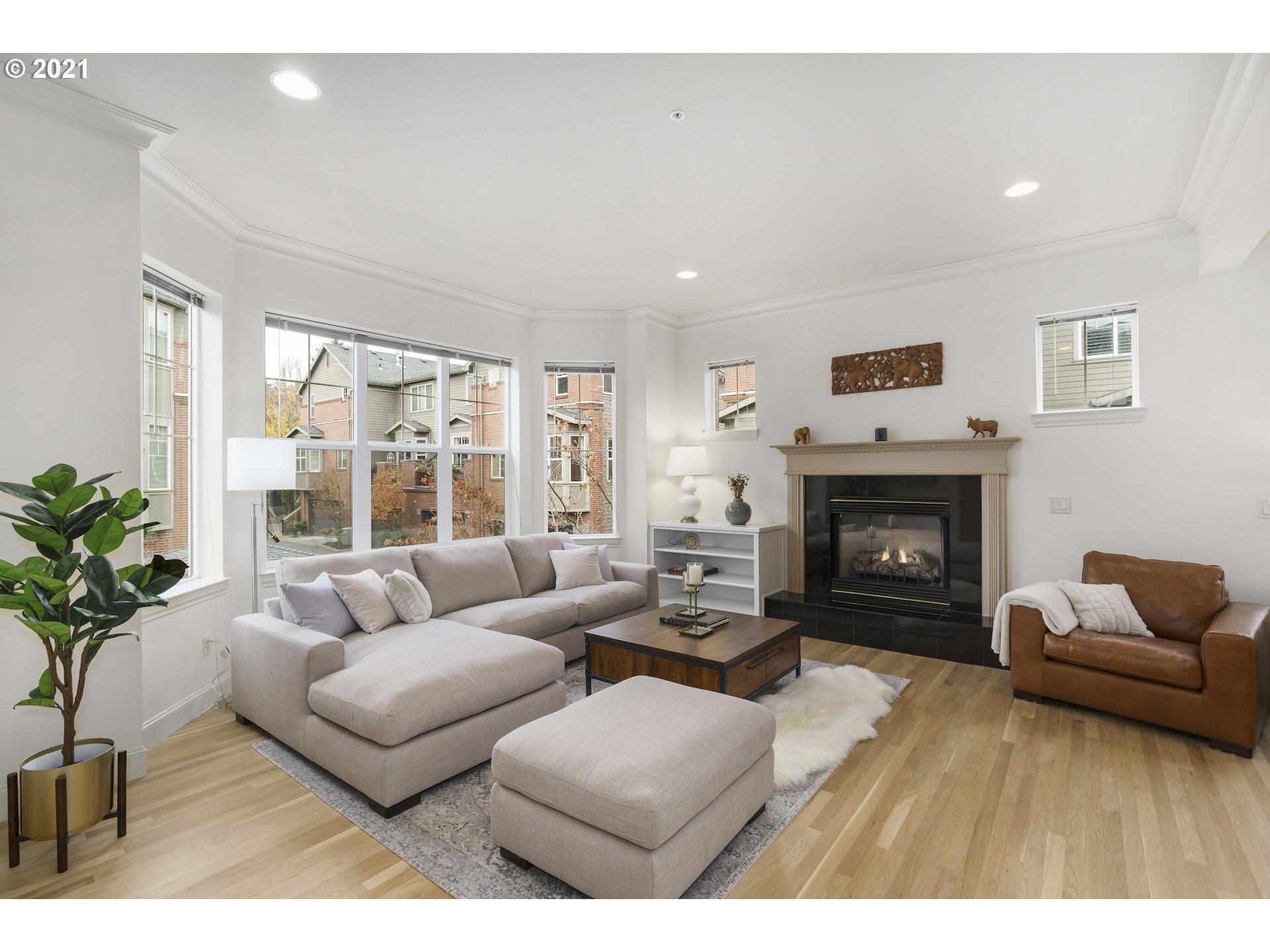2374 Northwest Raleigh Street Portland, OR 97210 - Photo 3 of 32 a living room with furniture a floor to ceiling window and a fireplace