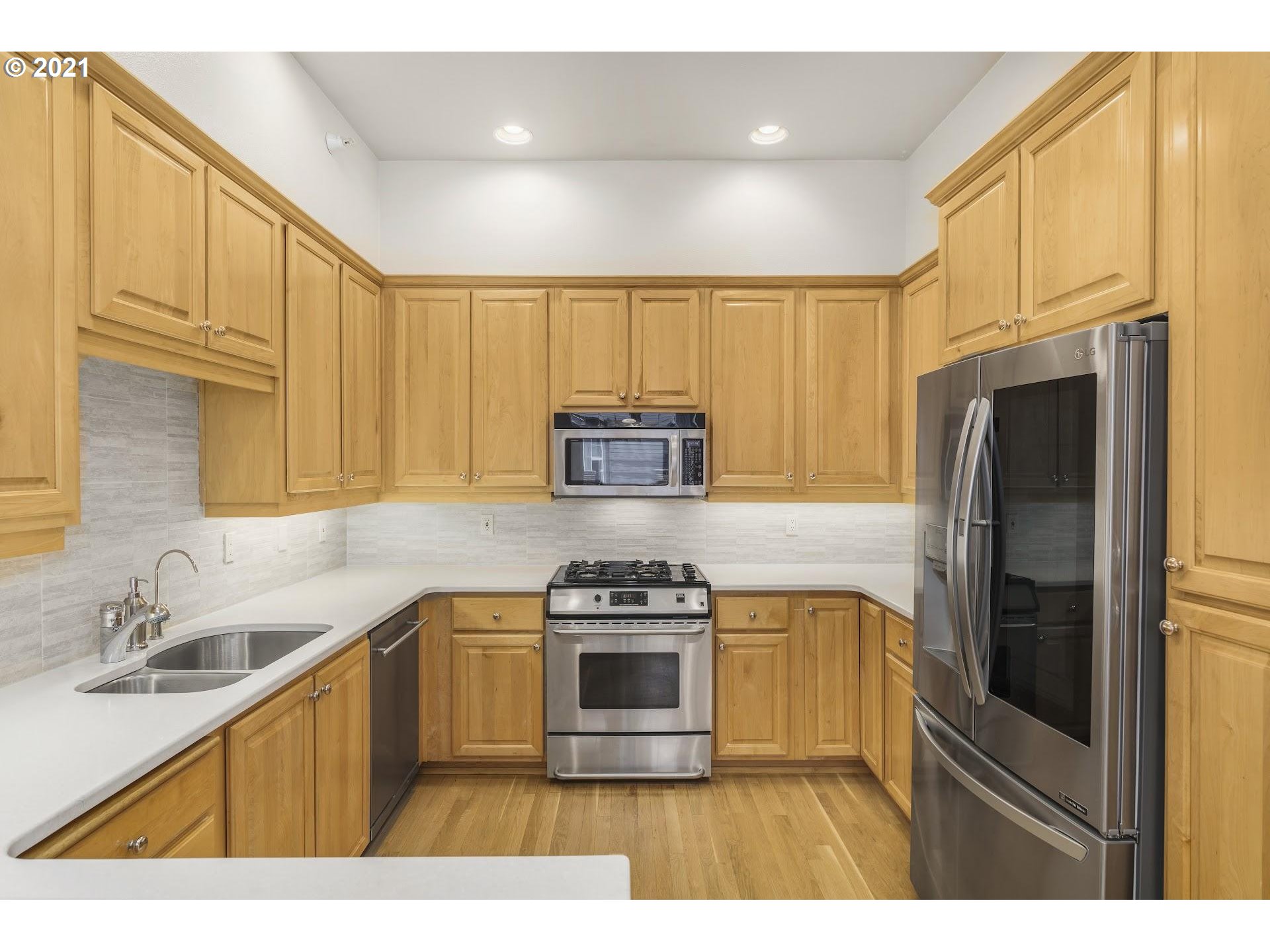 2374 Northwest Raleigh Street Portland, OR 97210 - Photo 8 of 32 a kitchen with kitchen island stainless steel appliances a stove a sink and a refrigerator