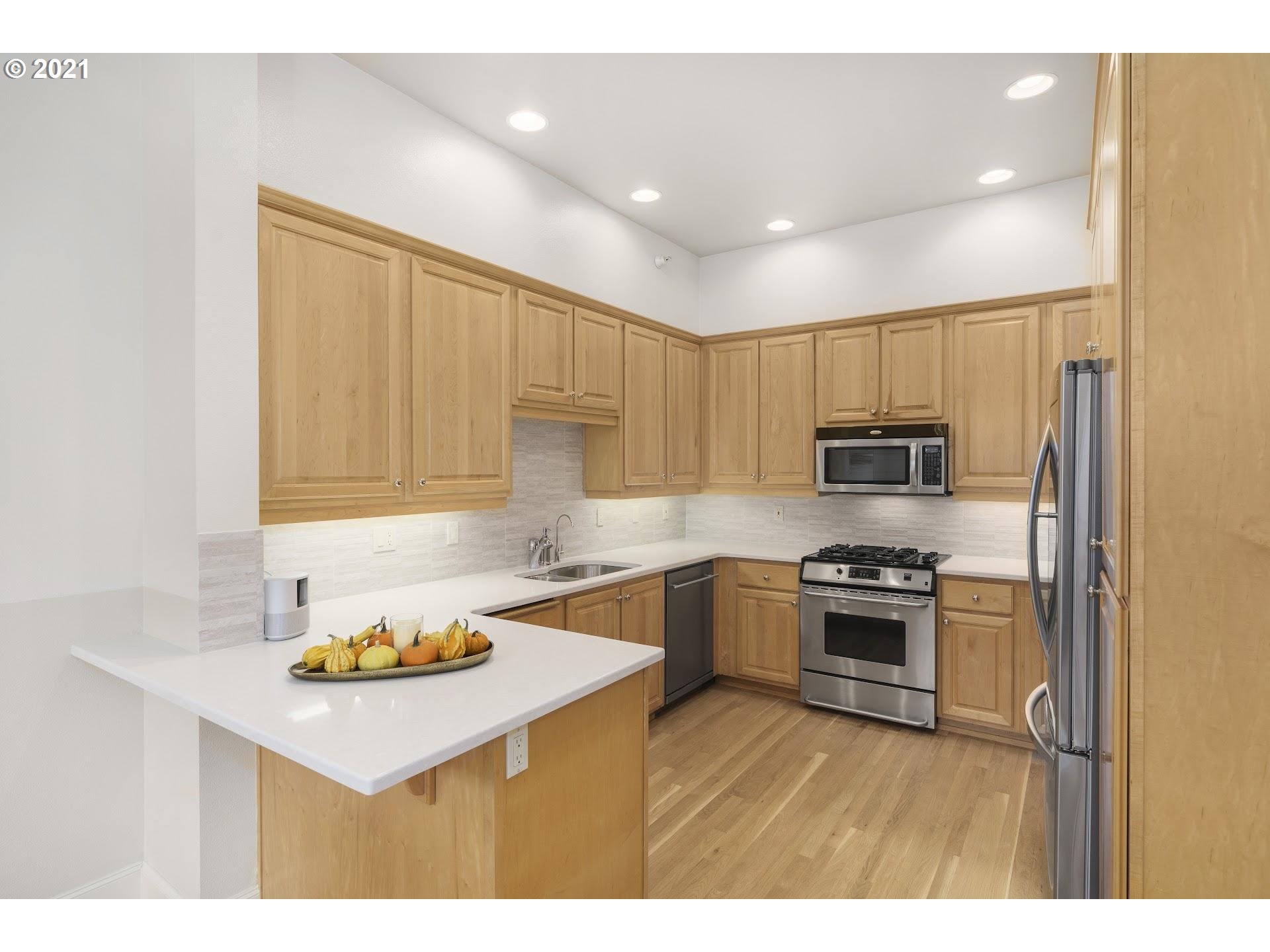 2374 Northwest Raleigh Street Portland, OR 97210 - Photo 9 of 32 a kitchen with stainless steel appliances a stove a sink a refrigerator and cabinets